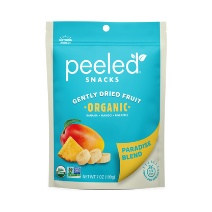 Peeled Snacks Gently Dried Fruit Paradise Blend organic food packaging, a vibrant turquoise blue stand-up pouch featuring illustrations of a ripe mango, pineapple wedge, and banana slices, with a yellow Paradise Blend label